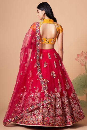 Dazzling Sangeet Wear Rani Color Lehenga Choli In Net Fabric